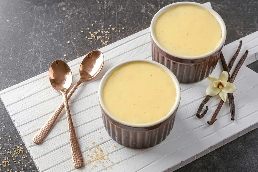 Crème vanille façon Danette maison dans des petits pots en verre, avec une gousse de vanille et une cuillère vintage